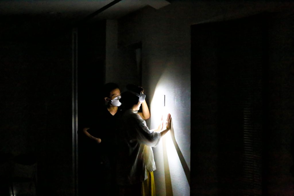 写真：暗闇の中で、ゴーグルをかけて作品を鑑賞する参加者。