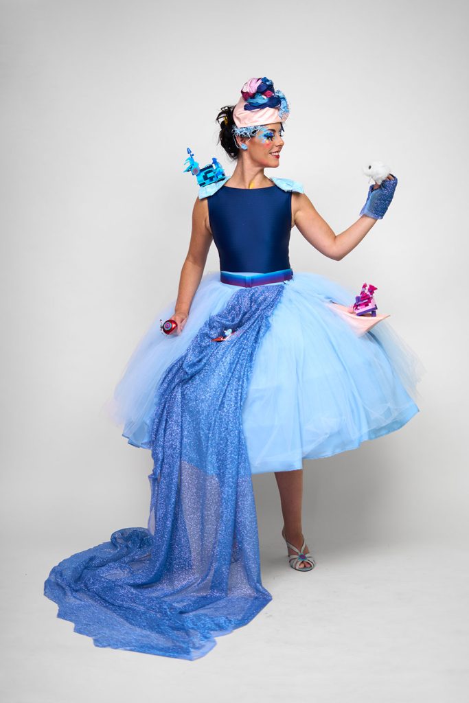 写真：ブルーのドレスとメイクをまとってポーズをとるアーティスト。